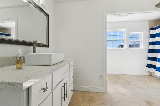 full bath with baseboards and vanity