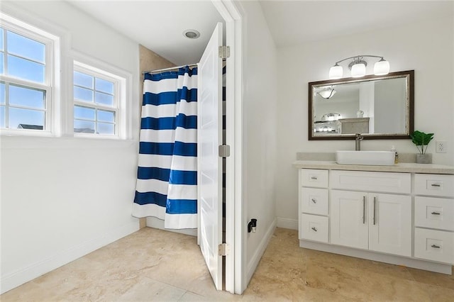 full bathroom featuring a shower with shower curtain, baseboards, and vanity