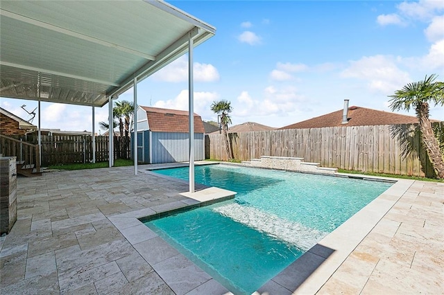 view of pool featuring a storage shed, a fenced in pool, a patio, a fenced backyard, and an outbuilding