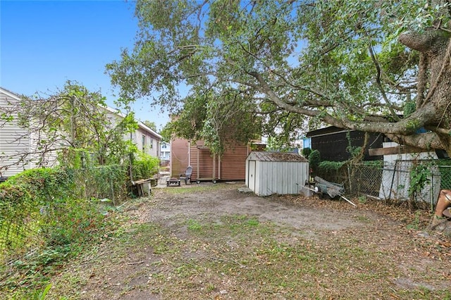 view of yard featuring a storage shed, an outdoor structure, and fence