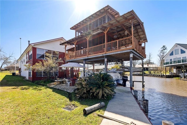 view of dock with a water view and a lawn