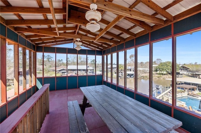 unfurnished sunroom with lofted ceiling, a healthy amount of sunlight, a water view, and a sauna