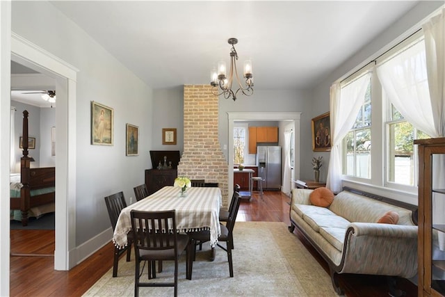 dining space with a chandelier, light wood-style flooring, and baseboards