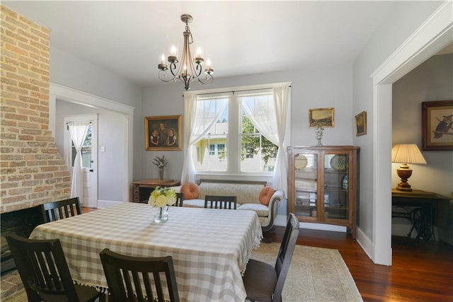 dining space featuring an inviting chandelier, baseboards, and wood finished floors