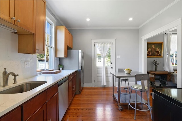 kitchen with plenty of natural light, dark wood-style flooring, a sink, and stainless steel dishwasher