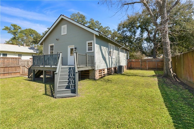 back of property with central air condition unit, a fenced backyard, a lawn, and a wooden deck