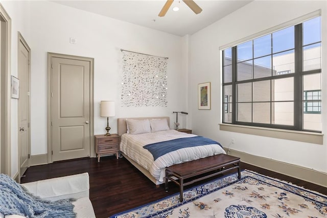 bedroom with ceiling fan, baseboards, and wood finished floors