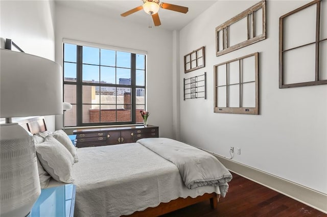 bedroom featuring a ceiling fan, baseboards, and wood finished floors