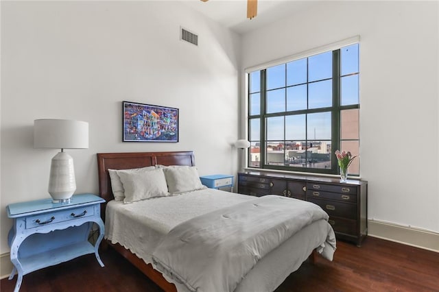 bedroom featuring dark wood-style floors, a ceiling fan, visible vents, and baseboards