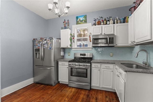 kitchen featuring stainless steel appliances, white cabinetry, a sink, and tasteful backsplash