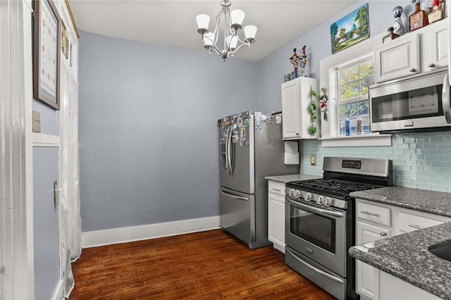 kitchen with tasteful backsplash, baseboards, dark wood finished floors, appliances with stainless steel finishes, and white cabinetry