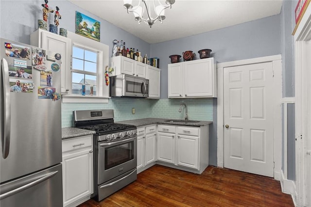 kitchen featuring appliances with stainless steel finishes, white cabinets, and a sink