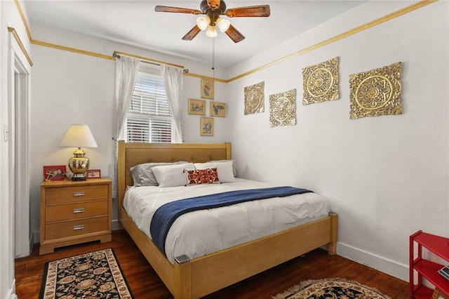 bedroom featuring a ceiling fan, baseboards, and wood finished floors