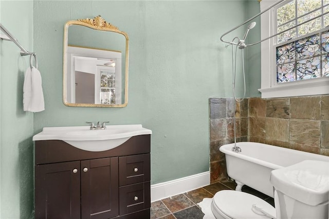 full bath featuring baseboards, toilet, walk in shower, a freestanding bath, and vanity