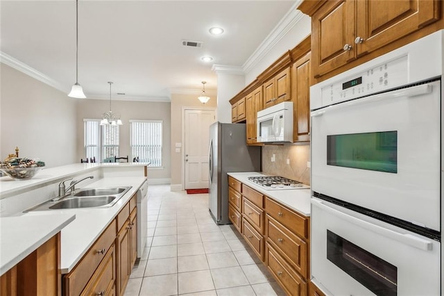 kitchen with white appliances, a sink, visible vents, ornamental molding, and brown cabinetry