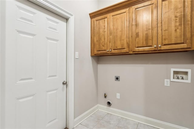 laundry area with light tile patterned floors, hookup for a washing machine, hookup for an electric dryer, baseboards, and cabinet space