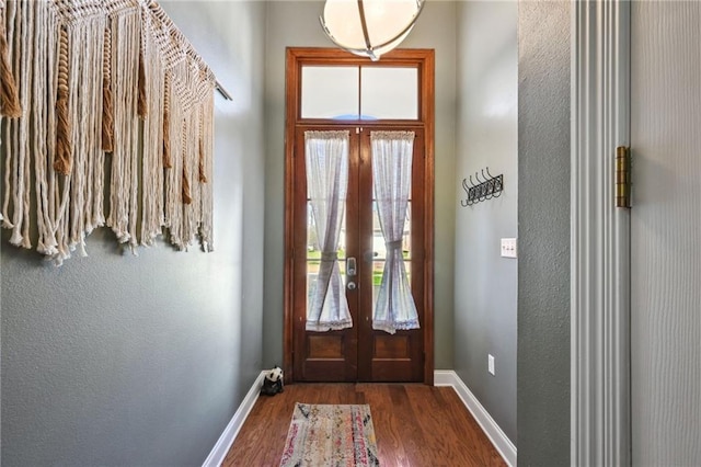 entryway featuring baseboards, wood finished floors, and french doors