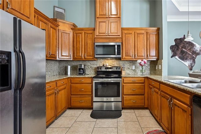 kitchen featuring stainless steel appliances, ornamental molding, and brown cabinetry