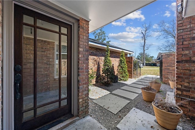 doorway to property featuring brick siding