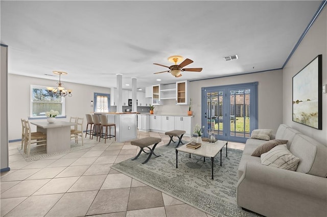 living room featuring light tile patterned floors, ceiling fan with notable chandelier, visible vents, and french doors