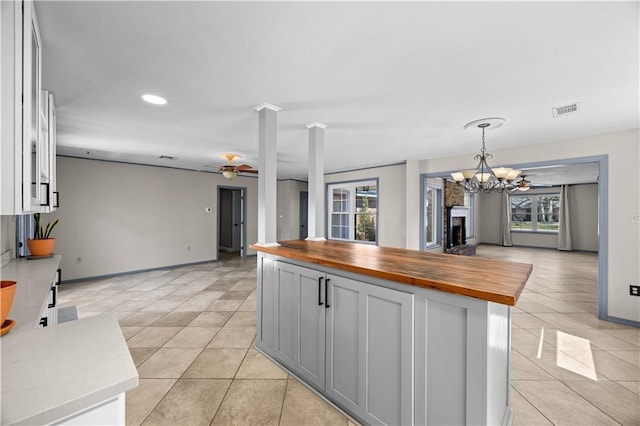 kitchen featuring open floor plan, butcher block counters, light tile patterned flooring, and visible vents