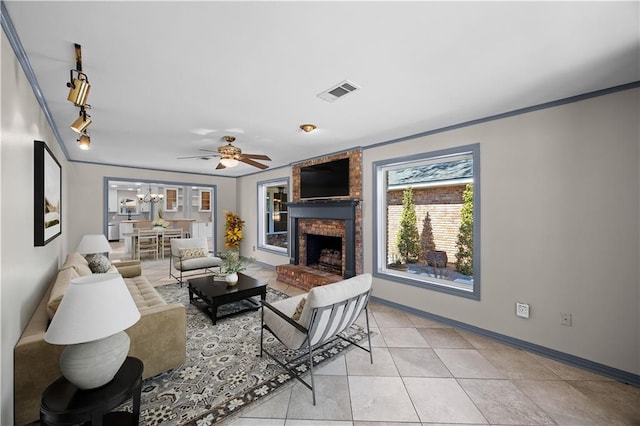 living room with light tile patterned floors, a fireplace, visible vents, baseboards, and rail lighting