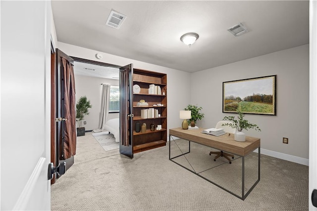 home office with baseboards, visible vents, and light colored carpet