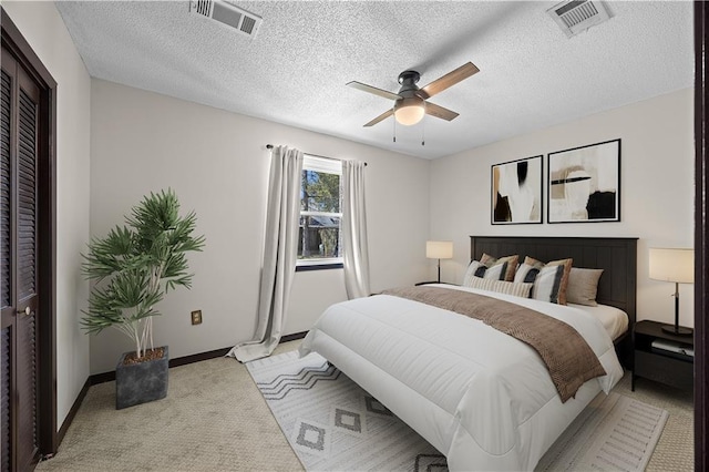 bedroom with a ceiling fan, light carpet, visible vents, and baseboards