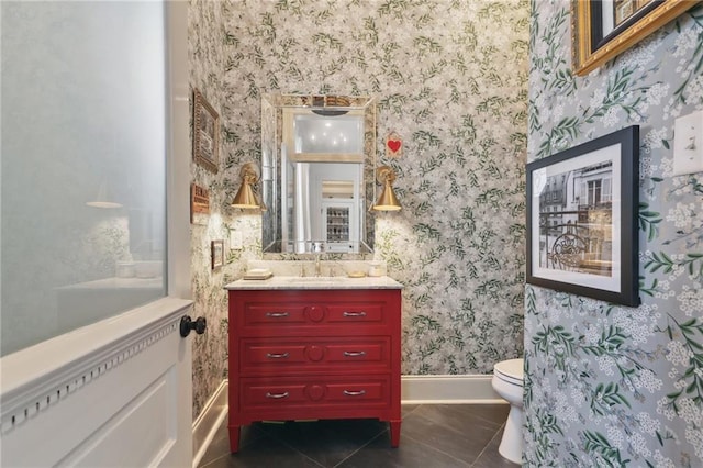 bathroom featuring toilet, wallpapered walls, tile patterned flooring, baseboards, and vanity