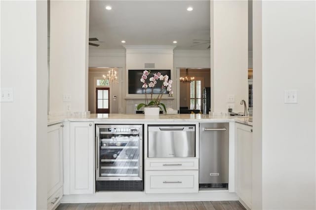 bar featuring wine cooler, recessed lighting, ceiling fan with notable chandelier, and ornamental molding