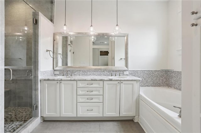 full bath with a sink, a garden tub, a stall shower, and double vanity