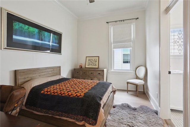 bedroom with light wood-style flooring, baseboards, and ornamental molding