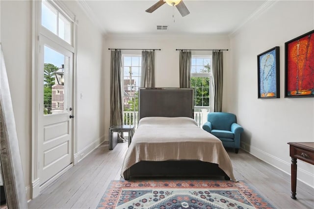 bedroom with light wood-type flooring, baseboards, visible vents, and crown molding