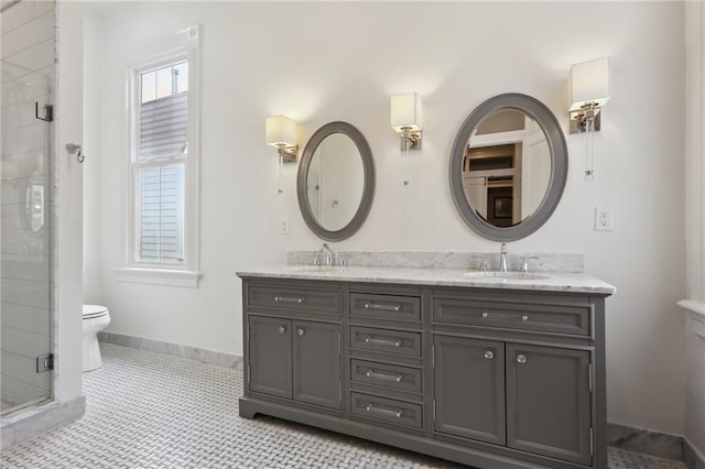 bathroom with a sink, toilet, double vanity, and a shower stall