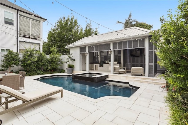 view of pool with a patio, a pool with connected hot tub, and fence