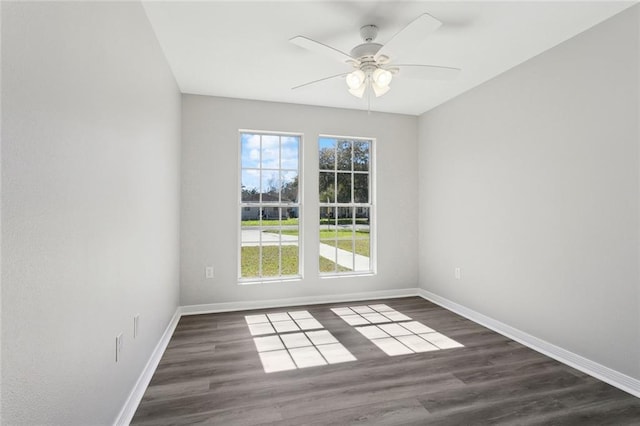 empty room featuring ceiling fan, baseboards, and wood finished floors