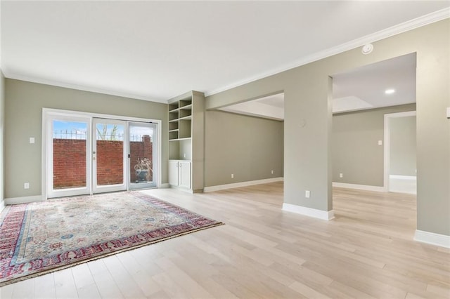 unfurnished living room with light wood-type flooring, baseboards, and crown molding