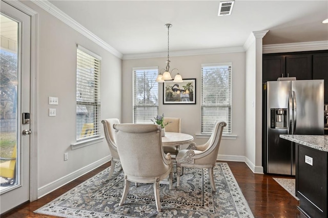 dining area with visible vents, baseboards, ornamental molding, dark wood-style floors, and an inviting chandelier