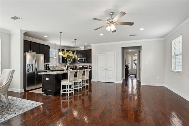 kitchen featuring stainless steel appliances, ornamental molding, dark wood-style flooring, and visible vents