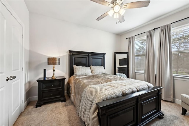 bedroom featuring baseboards, ceiling fan, and light colored carpet