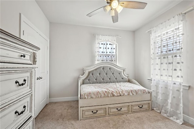 bedroom featuring ceiling fan, baseboards, and light colored carpet