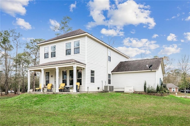 back of house with central air condition unit, a patio, and a yard