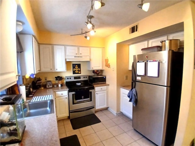 kitchen with under cabinet range hood, white cabinetry, visible vents, and stainless steel appliances