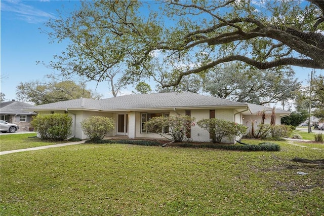 single story home featuring a garage, a front yard, and brick siding