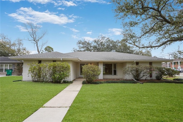 ranch-style home featuring brick siding and a front yard