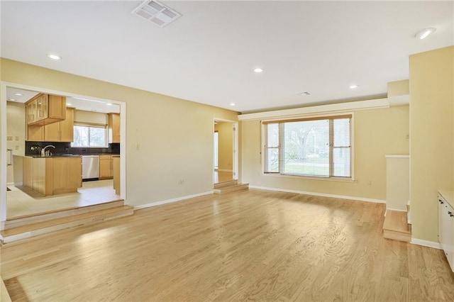 unfurnished living room with light wood finished floors, baseboards, visible vents, and recessed lighting