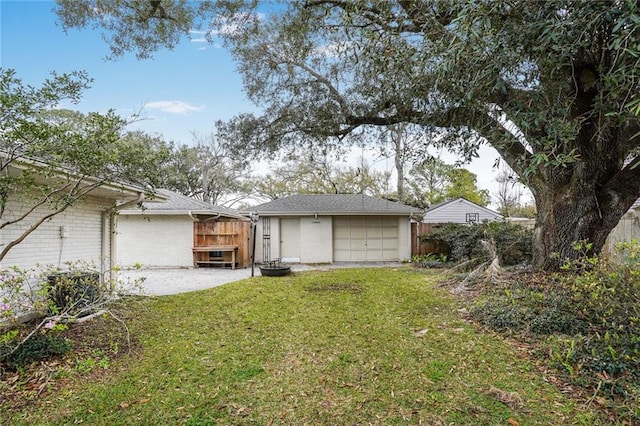 garage featuring driveway and fence