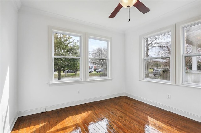 unfurnished room with ornamental molding, dark wood-style flooring, a ceiling fan, and baseboards