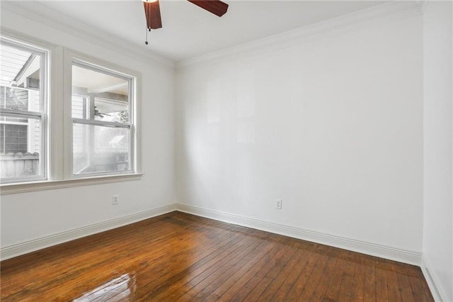 spare room with crown molding, dark wood finished floors, a ceiling fan, and baseboards