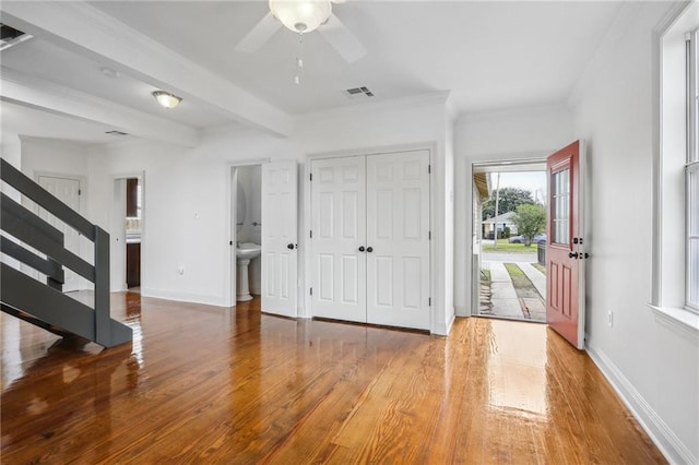 entrance foyer with baseboards, visible vents, wood finished floors, beamed ceiling, and stairs